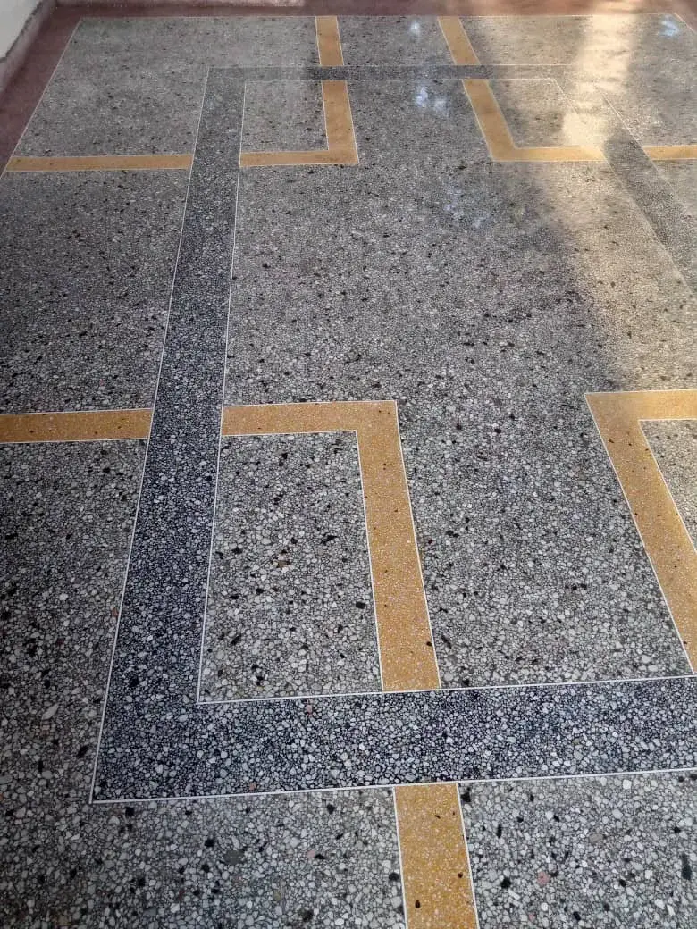Terrazzo floor with a grey border and gold inlay lines